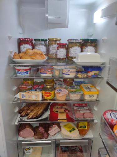 an open refrigerator filled with lots of food at Apartament Augustów SWAN in Augustów
