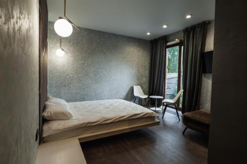 Un dormitorio con una cama y un espejo en la pared. en Sofa Boutique Hotel & SPA, en Sumy