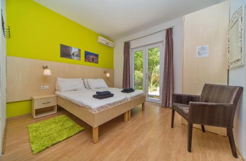 a bedroom with a bed and a green wall at Apartments Ante in Mlini