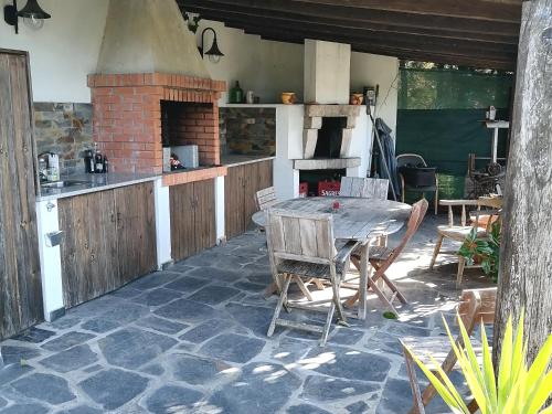 uma cozinha com uma mesa e um forno de tijolos em Bela Vista Alqueve - 2 houses with pool, 2 casas com piscina em Arganil
