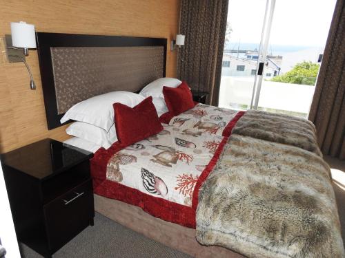 a bedroom with a large bed with red pillows at Fairways Holiday Accommodation in Drakensberg Garden