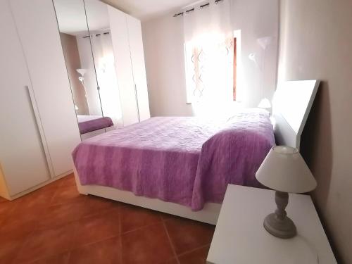 a bedroom with a purple bed and a mirror at calloni franceschini home in Palaia