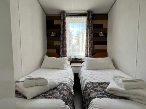 two beds in a small room with a window at Holiday Marina Resort in Grimaud