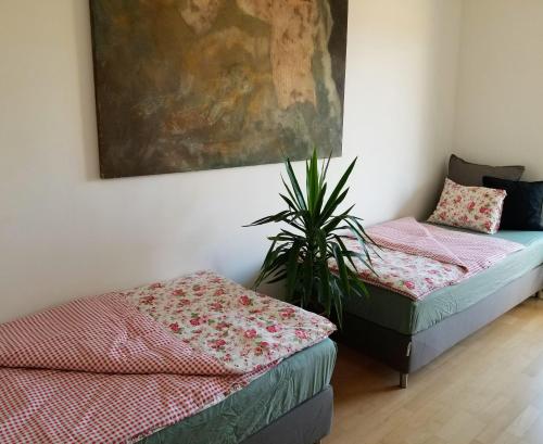 a room with two beds and a potted plant at New Pest Apartman in Budapest