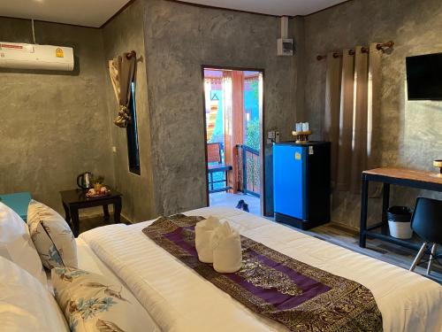 a bedroom with a large bed and a balcony at Khum Lanna Boutique Hotel in Si Sa Ket
