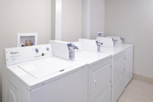 a row of white sinks in a white room at Holiday Inn Express Wixom by IHG in Wixom