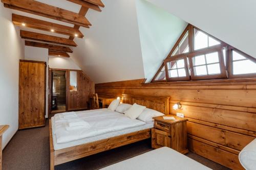 a bedroom with a bed in a room with wooden walls at Wellness penzión Kráľov dvor in Čremošné