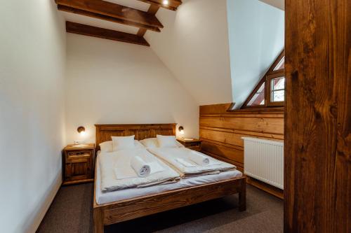 a bedroom with a large bed in a attic at Wellness penzión Kráľov dvor in Čremošné