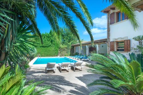 a villa with a swimming pool and palm trees at Owl Booking Villa La Font - Relax with a Big Pool in Pollença