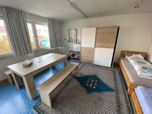 Schlafzimmer mit einem Bett, einem Schreibtisch und einem Tisch in der Unterkunft Carli's Bed-No-Breakfast in Friedrichshafen