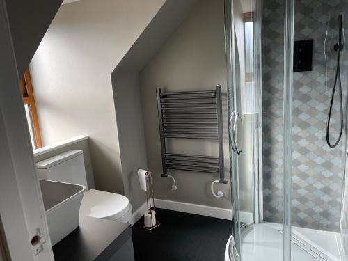 een badkamer met een douche en een wit toilet bij The Inn @ Y-Not in Thurso