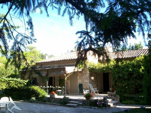a small stone house with a table and chairs at Mas Grimaud - Gîte- Studio et chambres d'hôtes familiales in Eygalières