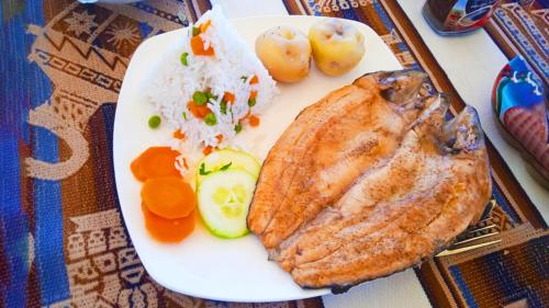 un plato de comida con carne, arroz y hortalizas en Vip Flotante en Puno