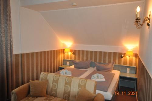 a bedroom with two beds and a couch at Parkhotel Schwedt in Schwedt