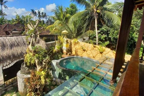 einen Pool in einem Garten mit einem Haus in der Unterkunft Kayu81- Beautiful Pool Vila Ubud Mountain View 2BR in Bedahulu