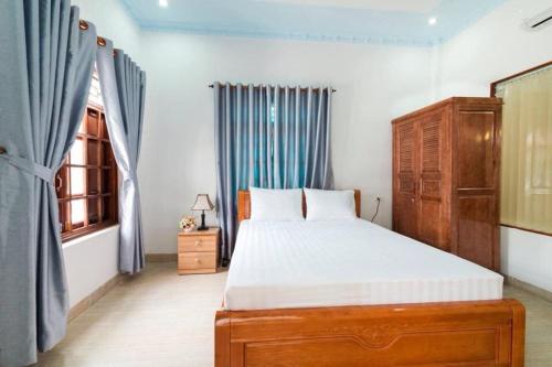 Un dormitorio con una cama grande y una ventana. en Wings Bungalow, en Phu Quoc