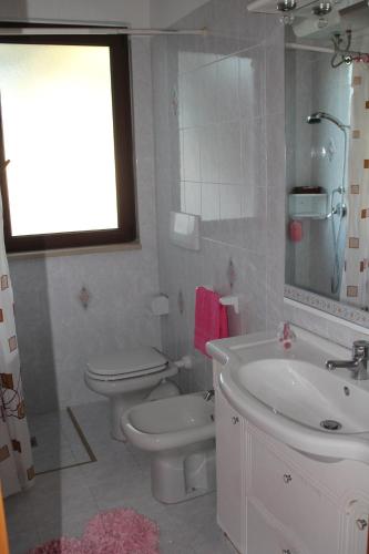 a white bathroom with a toilet and a sink at Ville Alba & Azzurra Accesso Privato al Mare in Polignano a Mare