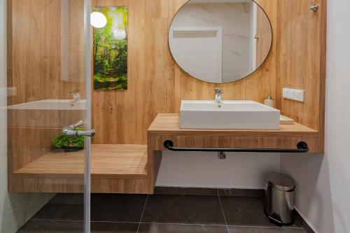 a bathroom with a sink and a mirror at VacationClub – Jantaris Apartament A24 in Mielno