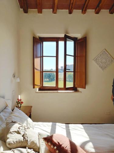a bedroom with a bed and a window at Hotel More di Cuna in Monteroni dʼArbia