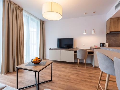 a living room with a table and a kitchen at VacationClub – Jantaris Apartament B35 in Mielno