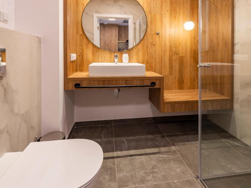 a bathroom with a sink and a mirror at VacationClub – Jantaris Apartament B35 in Mielno
