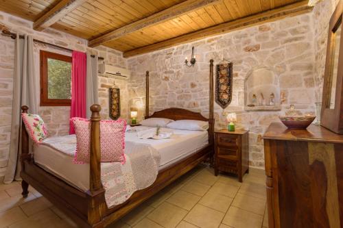 a bedroom with a bed and a stone wall at Garden of Eden in Kalamaki
