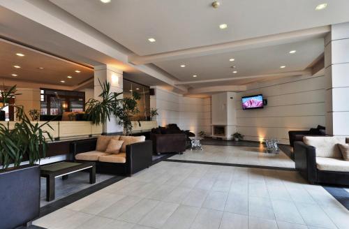a lobby with couches and a flat screen tv at Bellevue Residence Apartments in Bansko
