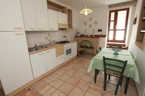 a kitchen with a table and a kitchen with a fireplace at Appartamenti Il Borgo in Rivotorto