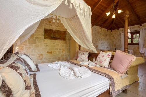 a bed in a room with two wicker chairs at Garden of Eden in Kalamaki