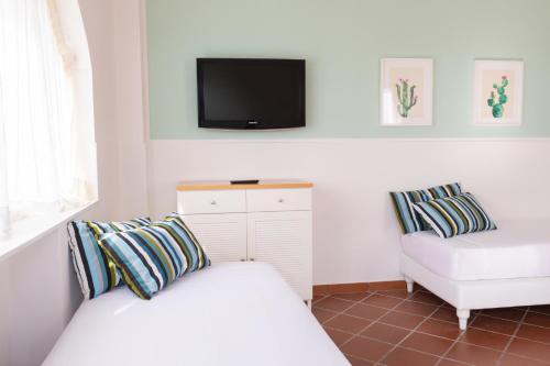 sypialnia z łóżkiem, telewizorem i krzesłem w obiekcie Lido Azzurro w mieście Numana