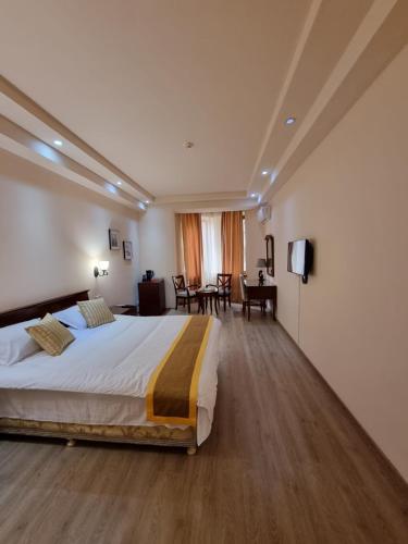 una habitación de hotel con una cama grande y una mesa en DaMus apartments, en Ereván