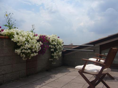 a chair on a balcony with flowers on a wall at The Flower Garden in Scanzorosciate