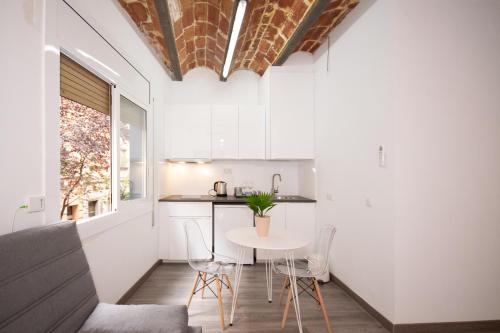 uma pequena cozinha com mesa e cadeiras num quarto em Apartahotel Casa Batito em L'Hospitalet de Llobregat