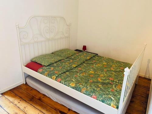 - une chambre avec un lit blanc et une couette verte dans l'établissement Appartement T2 sur la place du marché de Wazemmes, à Lille