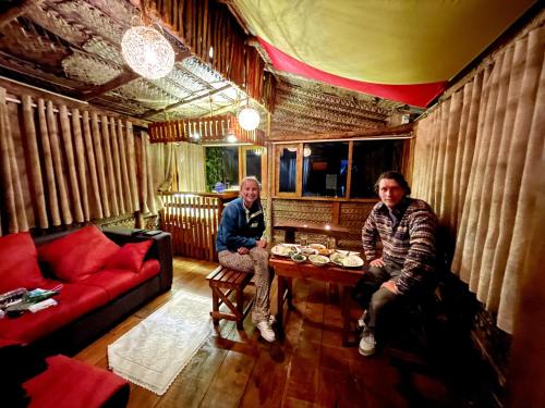 two men are sitting in a living room at La Luna Cabins in Nuwara Eliya