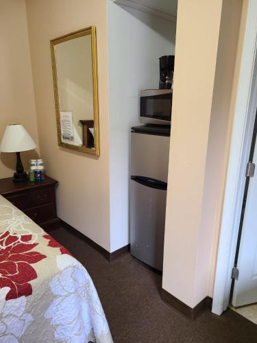 a hotel room with a bed and a mirror at Clarysville Motel in Frostburg