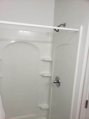a bathroom with a shower with a glass door at Clarysville Motel in Frostburg