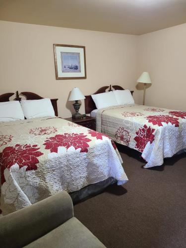 a hotel room with two beds and a couch at Clarysville Motel in Frostburg