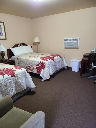 a hotel room with two beds and a fan at Clarysville Motel in Frostburg