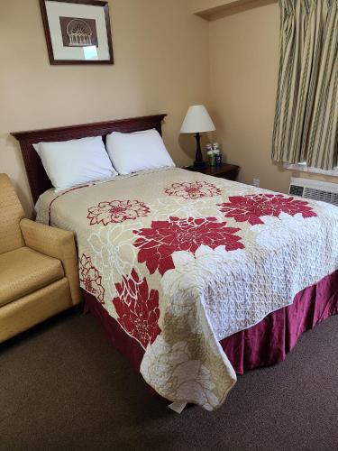 a bedroom with a bed with a red and white blanket at Clarysville Motel in Frostburg
