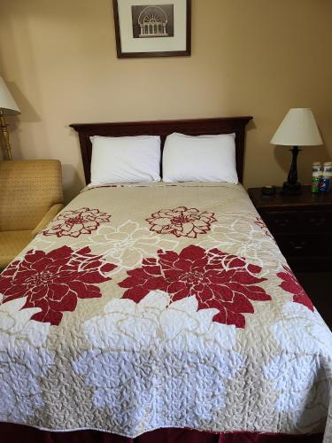 a bedroom with a bed with a flower quilt on it at Clarysville Motel in Frostburg