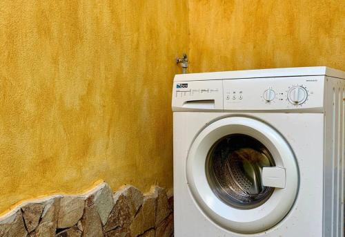 a white washing machine sitting next to a wall at Villa Magnolia in Chia
