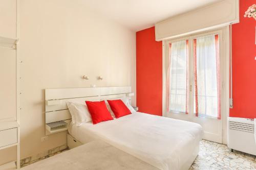 um quarto com paredes vermelhas e uma cama com almofadas vermelhas em The Red Loft in Ponte Vecchio em Florença