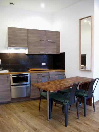 une cuisine avec une table et des chaises en bois dans l'établissement CityCosy-Strasbourg : Kleber Fashion Style, à Strasbourg