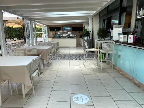 a restaurant with tables and chairs and a counter at Hotel Franca in Milano Marittima