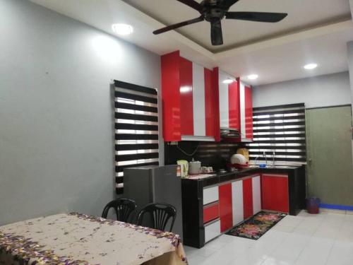 una cocina con armarios rojos y blancos y una mesa en D'Haja 56 KLIA SEPANG with 3 AIRCONDS & FREE Wi-Fi en Banting
