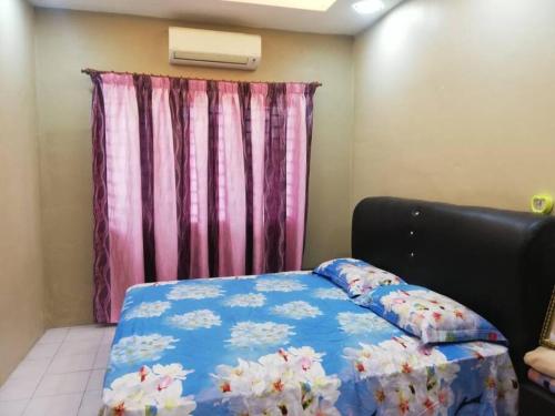 Un dormitorio con una cama con una manta azul con flores en D'Haja 56 KLIA SEPANG with 3 AIRCONDS & FREE Wi-Fi en Banting