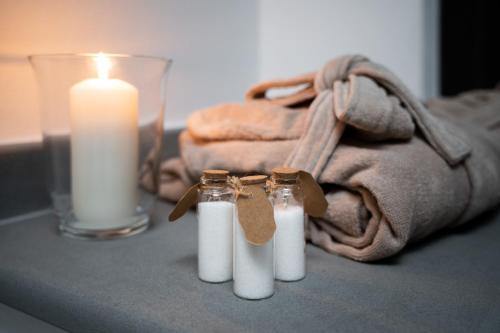 a candle and two bottles on a table with a towel at F1RST Suite Apartment & SPA in Florence