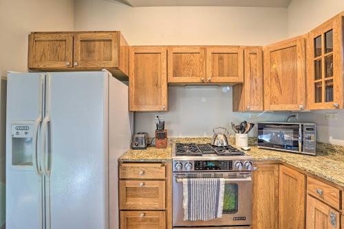 a kitchen with wooden cabinets and a white refrigerator at Ketchum Couples Retreat 1 Mi to Sun Valley! in Ketchum