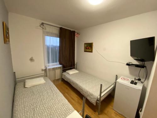 Habitación con 2 camas y TV de pantalla plana. en Pokoje Warszawa Modlinska 267 No 2, en Varsovia